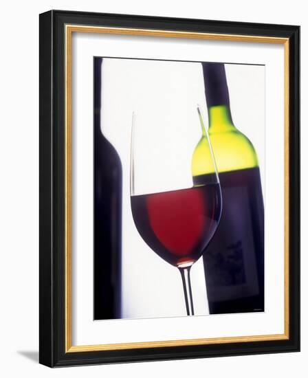 A Glass of Red Wine with a Bottle in the Background-Armin Faber-Framed Photographic Print