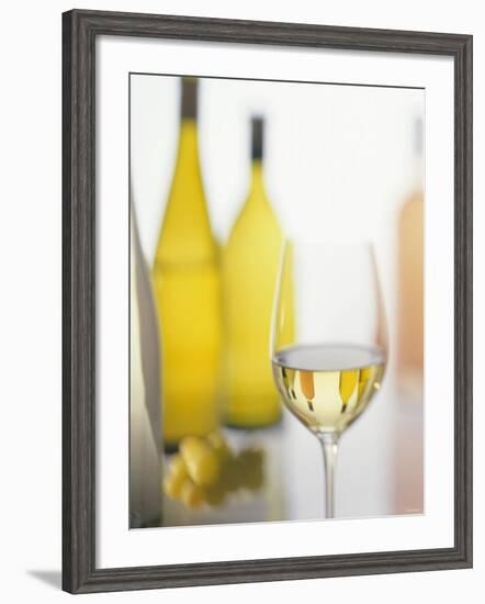 A Glass of White Wine and Wine Bottles in Background-Ulrike Koeb-Framed Photographic Print