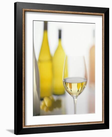 A Glass of White Wine and Wine Bottles in Background-Ulrike Koeb-Framed Photographic Print