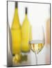 A Glass of White Wine and Wine Bottles in Background-Ulrike Koeb-Mounted Photographic Print