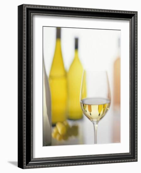 A Glass of White Wine and Wine Bottles in Background-Ulrike Koeb-Framed Photographic Print