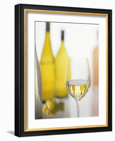 A Glass of White Wine and Wine Bottles in Background-Ulrike Koeb-Framed Photographic Print