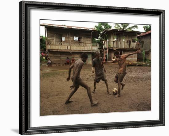 A Group of Panamanian Youths Slide Through the Mud During a Pick-Up Game of Soccer-null-Framed Photographic Print