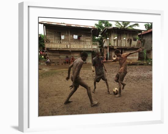 A Group of Panamanian Youths Slide Through the Mud During a Pick-Up Game of Soccer-null-Framed Photographic Print