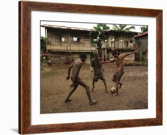 A Group of Panamanian Youths Slide Through the Mud During a Pick-Up Game of Soccer-null-Framed Photographic Print