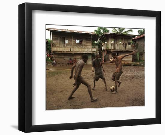 A Group of Panamanian Youths Slide Through the Mud During a Pick-Up Game of Soccer-null-Framed Photographic Print