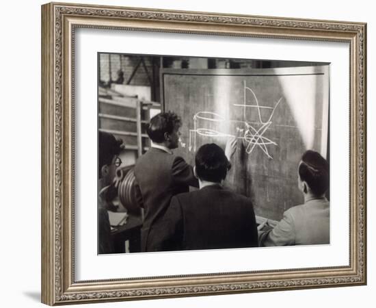 A Group of Scientists Study a Problem by Using Diagrams on a Blackboard-Henry Grant-Framed Photographic Print