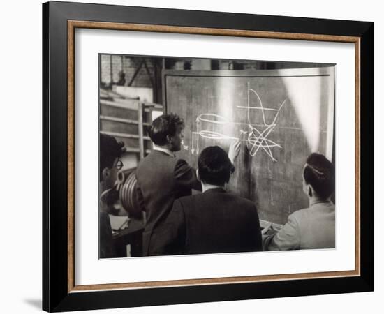 A Group of Scientists Study a Problem by Using Diagrams on a Blackboard-Henry Grant-Framed Photographic Print