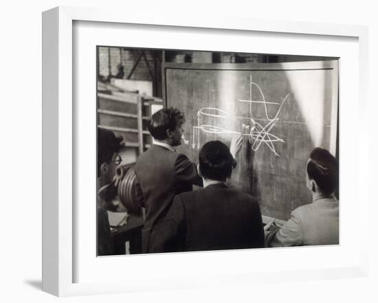 A Group of Scientists Study a Problem by Using Diagrams on a Blackboard-Henry Grant-Framed Photographic Print