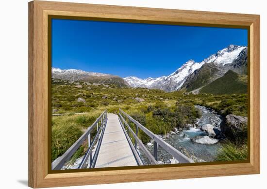 A hiking trail crosses wooden bridge over a creak high up in the mountains, New Zealand-Logan Brown-Framed Premier Image Canvas