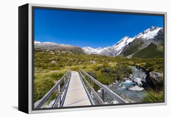 A hiking trail crosses wooden bridge over a creak high up in the mountains, New Zealand-Logan Brown-Framed Premier Image Canvas