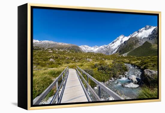 A hiking trail crosses wooden bridge over a creak high up in the mountains, New Zealand-Logan Brown-Framed Premier Image Canvas