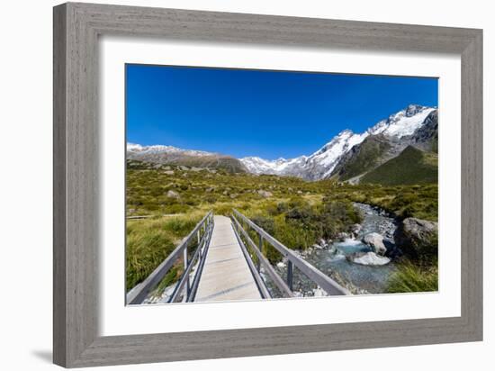 A hiking trail crosses wooden bridge over a creak high up in the mountains, New Zealand-Logan Brown-Framed Photographic Print