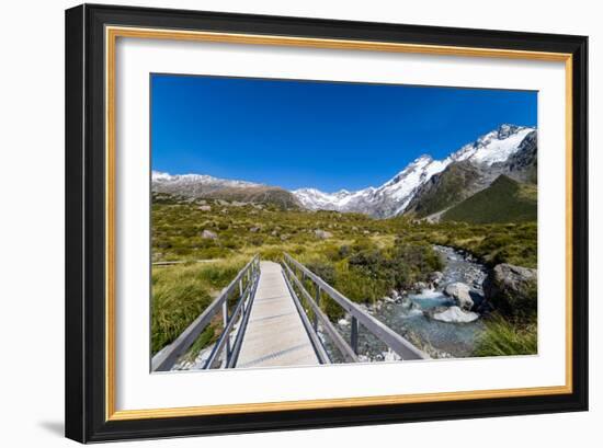 A hiking trail crosses wooden bridge over a creak high up in the mountains, New Zealand-Logan Brown-Framed Photographic Print