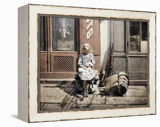 A Little Girl Playing with Her Doll; Two Guns and a Knapsack are Next to He-Fernand Cuville-Framed Premier Image Canvas