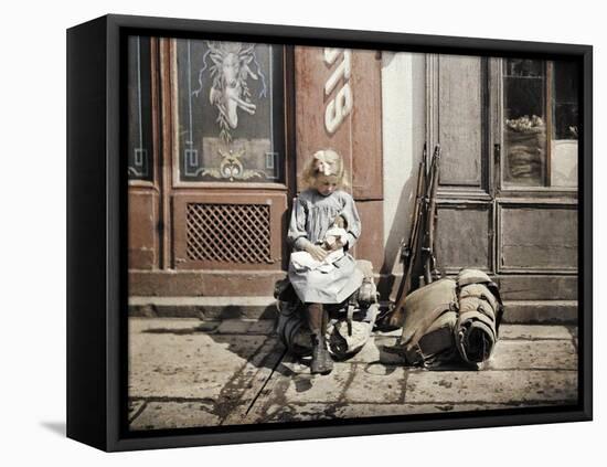 A Little Girl Playing with Her Doll; Two Guns and a Knapsack are Next to He-Fernand Cuville-Framed Premier Image Canvas