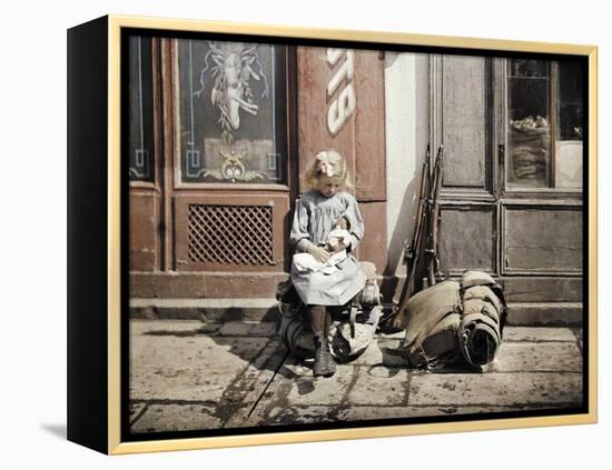 A Little Girl Playing with Her Doll; Two Guns and a Knapsack are Next to He-Fernand Cuville-Framed Premier Image Canvas