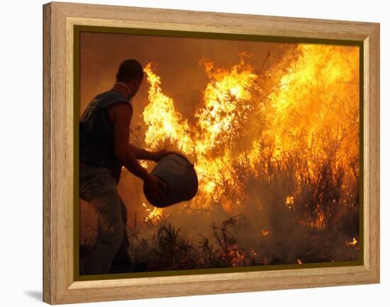 A Local Resident Throws a Bucket of Water on a Forest Fire-null-Framed Premier Image Canvas