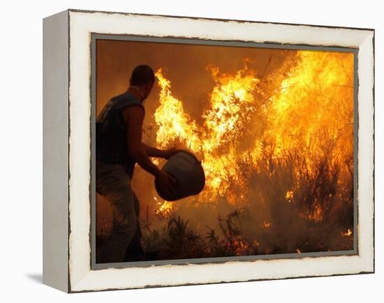 A Local Resident Throws a Bucket of Water on a Forest Fire-null-Framed Premier Image Canvas