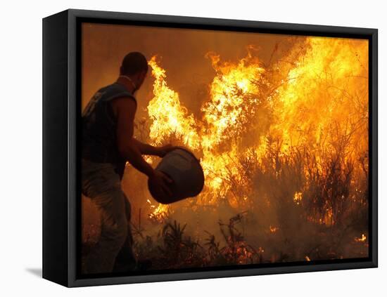 A Local Resident Throws a Bucket of Water on a Forest Fire-null-Framed Premier Image Canvas