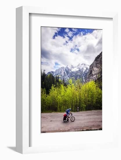 A Lone Cyclist Travels Along a Mountain Road with Trees and the Julian Alps in the Background-Sean Cooper-Framed Photographic Print