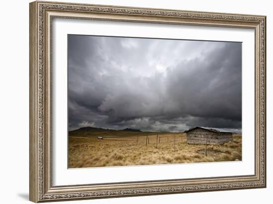 A Lone Hut Sits In The Grass As Storm Clouds Brew Over The Peruvian Countryside-Karine Aigner-Framed Photographic Print