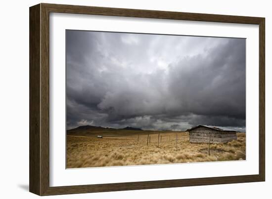 A Lone Hut Sits In The Grass As Storm Clouds Brew Over The Peruvian Countryside-Karine Aigner-Framed Photographic Print