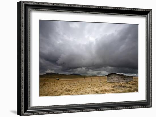 A Lone Hut Sits In The Grass As Storm Clouds Brew Over The Peruvian Countryside-Karine Aigner-Framed Photographic Print