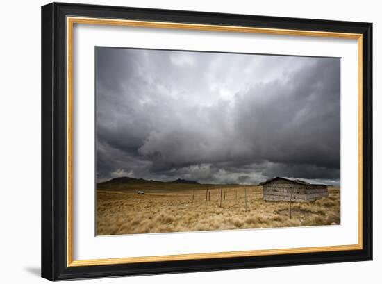 A Lone Hut Sits In The Grass As Storm Clouds Brew Over The Peruvian Countryside-Karine Aigner-Framed Photographic Print