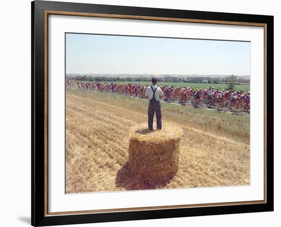 A Lone Spectator Watches the Pack Ride by from the Top of a Bale of Hay-null-Framed Photographic Print