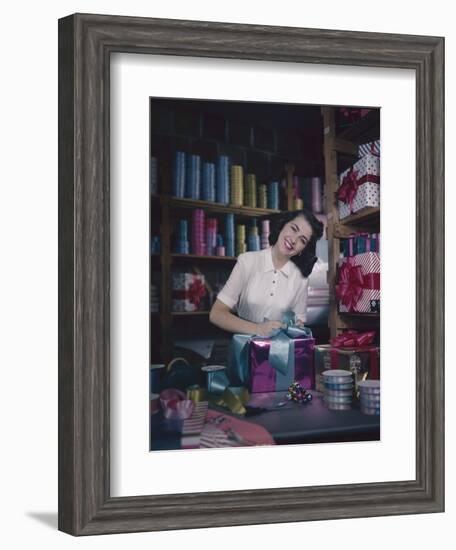 A Macy's Employee Ties a Bow onto a Present at a Gift Wrapping Counter, New York, New York, 1948-Nina Leen-Framed Photographic Print