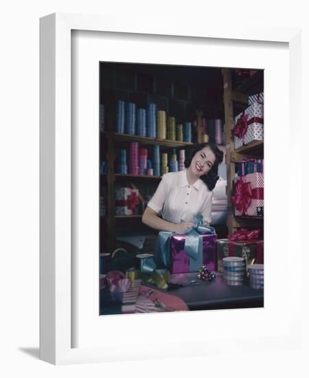 A Macy's Employee Ties a Bow onto a Present at a Gift Wrapping Counter, New York, New York, 1948-Nina Leen-Framed Photographic Print