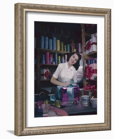 A Macy's Employee Ties a Bow onto a Present at a Gift Wrapping Counter, New York, New York, 1948-Nina Leen-Framed Photographic Print