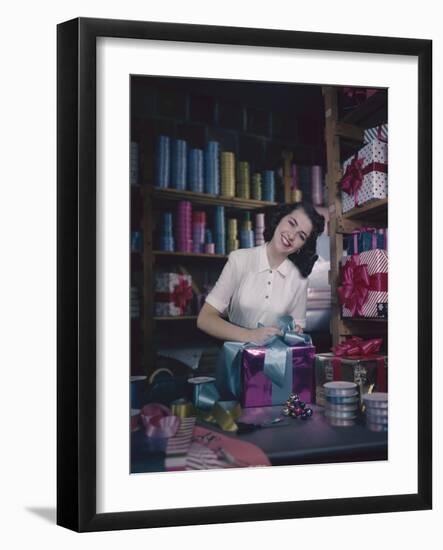 A Macy's Employee Ties a Bow onto a Present at a Gift Wrapping Counter, New York, New York, 1948-Nina Leen-Framed Photographic Print