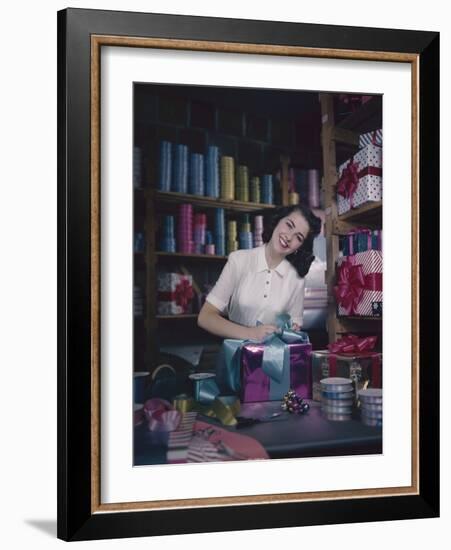 A Macy's Employee Ties a Bow onto a Present at a Gift Wrapping Counter, New York, New York, 1948-Nina Leen-Framed Photographic Print