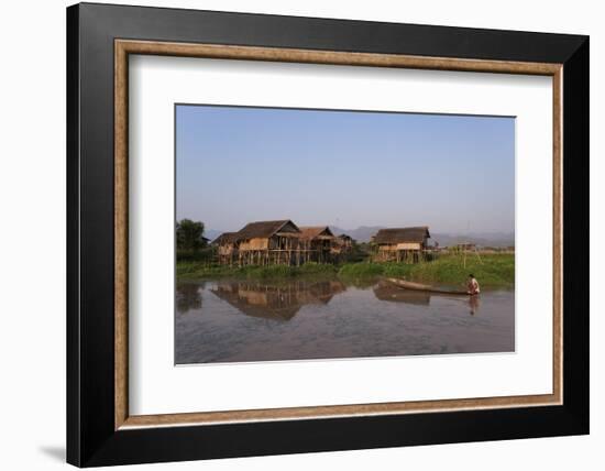 A man paddles his canoe past one of the floating villages on Inle Lake, Myanmar (Burma), Asia-Alex Treadway-Framed Photographic Print