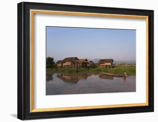 A man paddles his canoe past one of the floating villages on Inle Lake, Myanmar (Burma), Asia-Alex Treadway-Framed Photographic Print