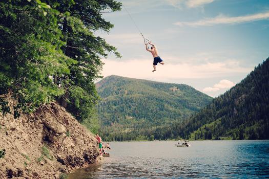 A Man Swings From A Rope Swing Into A Lake At Smith And Morehouse  Reservoir, Utah' Photographic Print - Lindsay Daniels 