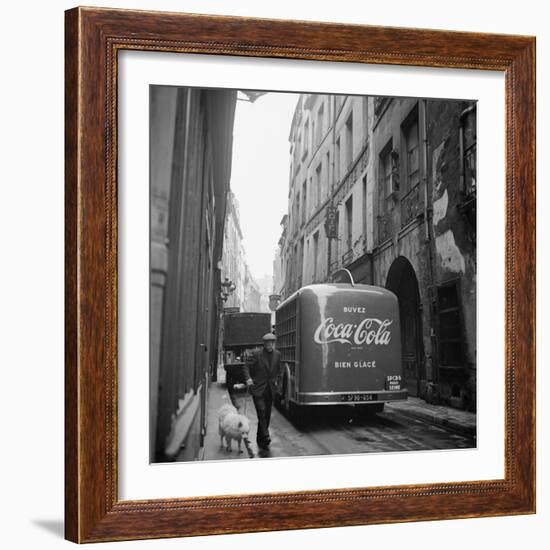 A Man Walks His Dog Beside a Bus with Coca Cola Advertisement, France, 1950-Mark Kauffman-Framed Photographic Print