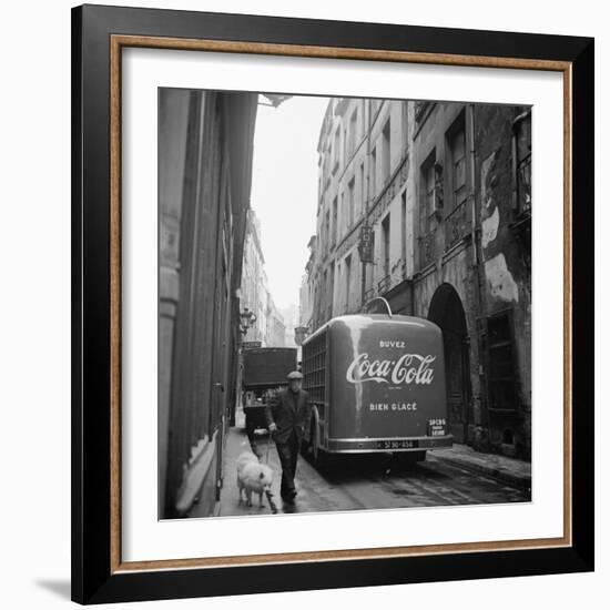 A Man Walks His Dog Beside a Bus with Coca Cola Advertisement, France, 1950-Mark Kauffman-Framed Photographic Print