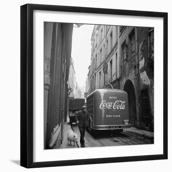 A Man Walks His Dog Beside a Bus with Coca Cola Advertisement, France, 1950-Mark Kauffman-Framed Photographic Print