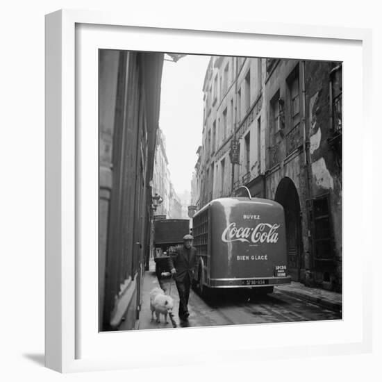 A Man Walks His Dog Beside a Bus with Coca Cola Advertisement, France, 1950-Mark Kauffman-Framed Photographic Print