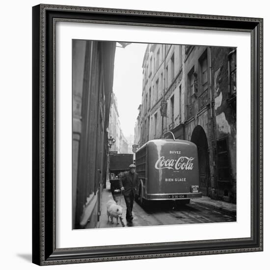 A Man Walks His Dog Beside a Bus with Coca Cola Advertisement, France, 1950-Mark Kauffman-Framed Photographic Print