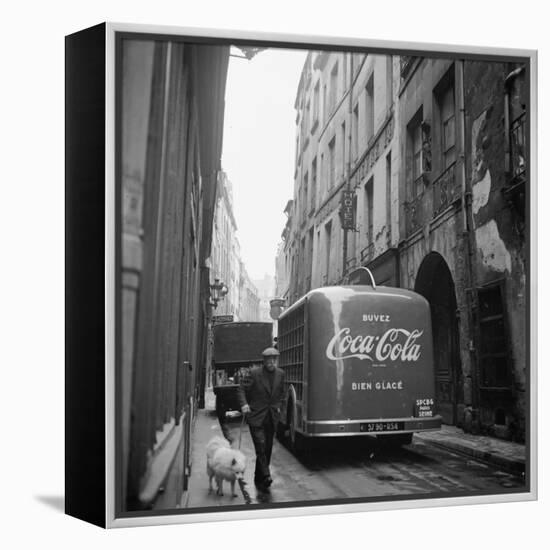 A Man Walks His Dog Beside a Bus with Coca Cola Advertisement, France, 1950-Mark Kauffman-Framed Premier Image Canvas