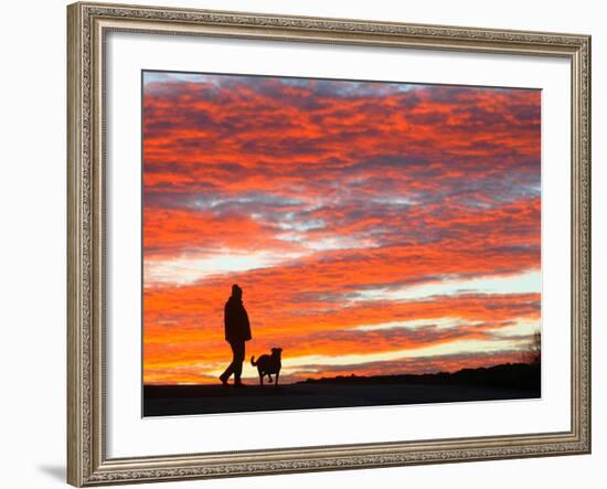 A Man Walks His Dog Under a Red Sky-null-Framed Photographic Print