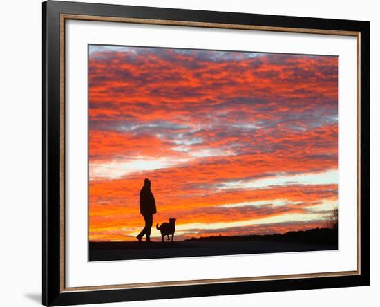 A Man Walks His Dog Under a Red Sky-null-Framed Photographic Print