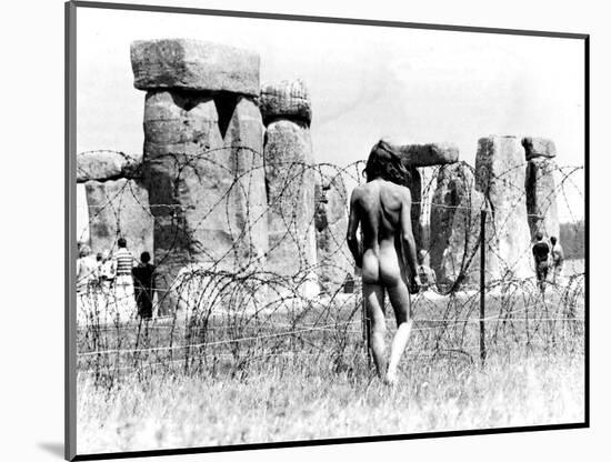 A Naked Hippy Watches Stonehenge from Behind Barb Wire on Summer Solstice-null-Mounted Photographic Print