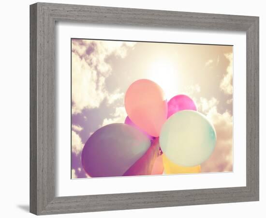 A Person Holding Multi Colored Balloons Done with a Retro Vintage Instagram Filter Effect-graphicphoto-Framed Photographic Print