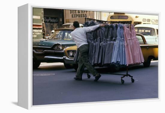 A Push Boy Steers a Rack of Dresses across an Intersection, New York, New York, 1960-Walter Sanders-Framed Premier Image Canvas