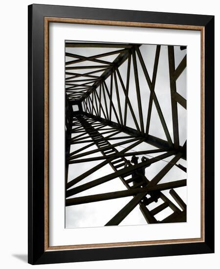 A Reenactor is Silhouetted Inside a Replica of the Spindletop Oil Derrick-null-Framed Photographic Print